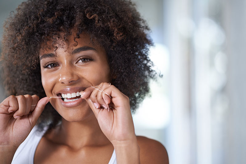 Woman flossing her teeth